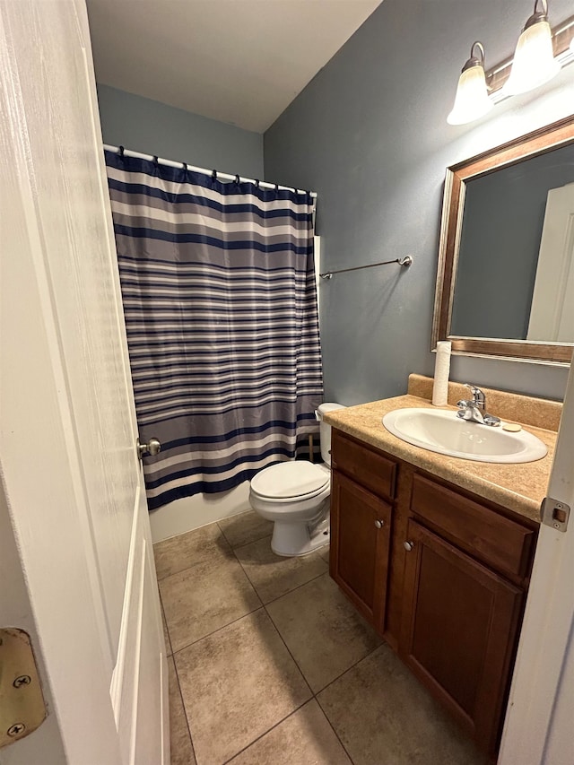 bathroom with toilet, vanity, tile patterned floors, and walk in shower