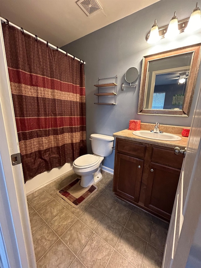 full bathroom featuring tile patterned floors, shower / bathtub combination with curtain, vanity, and toilet