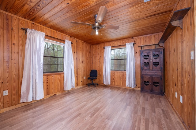 empty room with wood walls, wooden ceiling, ceiling fan, and light hardwood / wood-style flooring