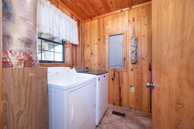 clothes washing area with wood walls, separate washer and dryer, light tile patterned floors, wood ceiling, and electric panel