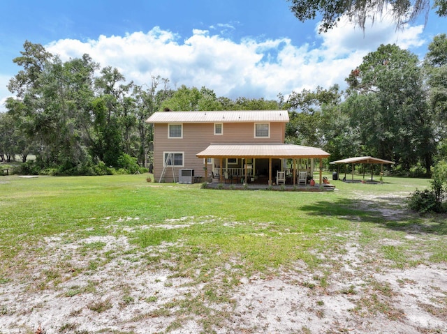 back of house featuring covered porch, a lawn, and central AC