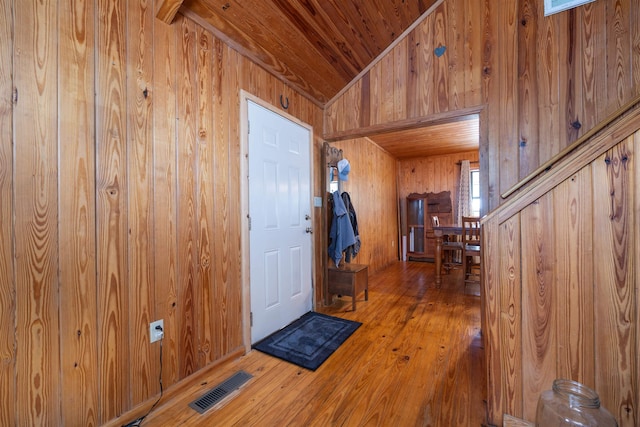 entrance foyer featuring wood walls, wood-type flooring, lofted ceiling, and wood ceiling