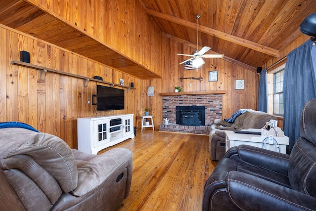 living room with lofted ceiling with beams, light wood-type flooring, wooden walls, wooden ceiling, and ceiling fan