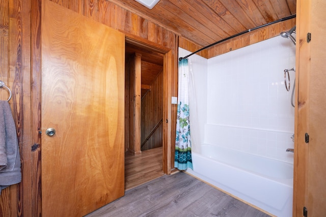 bathroom with hardwood / wood-style floors, wooden walls, shower / tub combo with curtain, and wooden ceiling