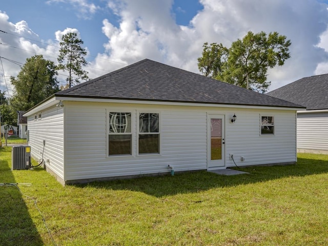 back of property with a yard and central AC