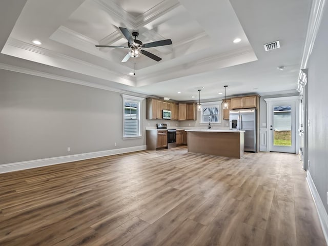 kitchen with a center island, hanging light fixtures, light wood-type flooring, ornamental molding, and stainless steel appliances