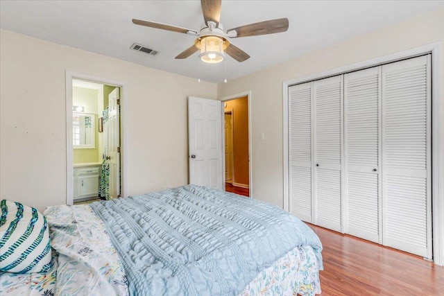 bedroom with hardwood / wood-style flooring, ceiling fan, connected bathroom, and a closet