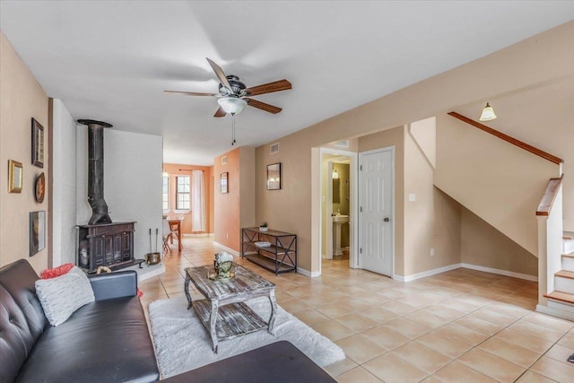 tiled living room with ceiling fan and a wood stove