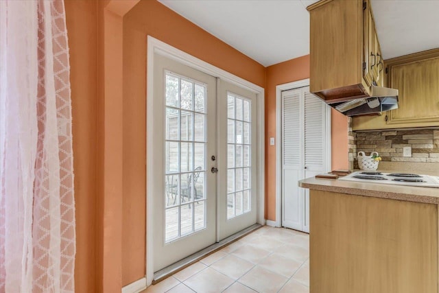 entryway with light tile patterned floors and french doors