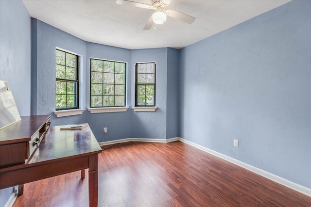 unfurnished office featuring ceiling fan and wood-type flooring