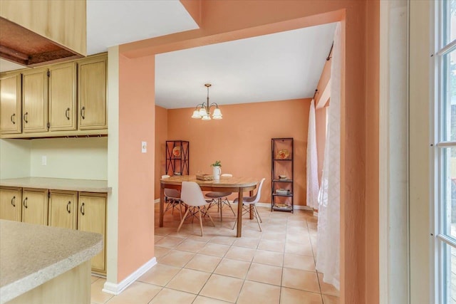 tiled dining area featuring an inviting chandelier