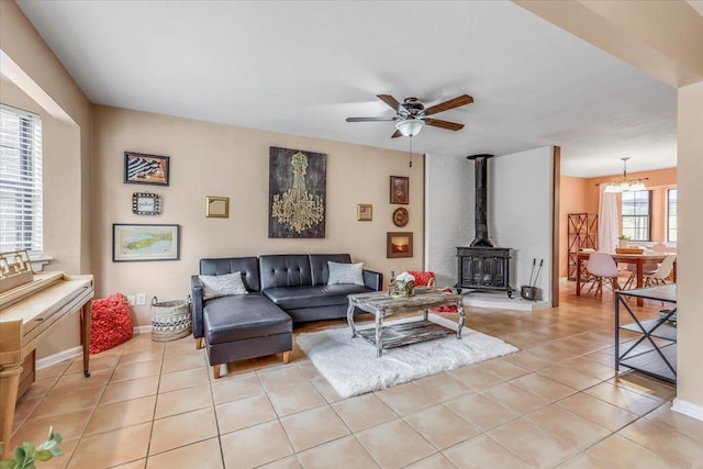 tiled living room with ceiling fan and a wood stove