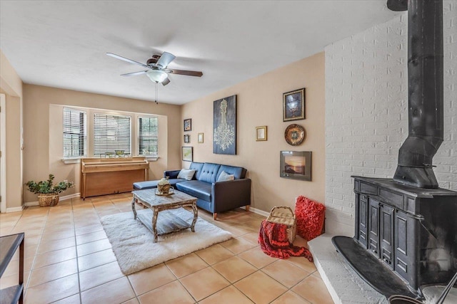 tiled living room featuring ceiling fan and a wood stove