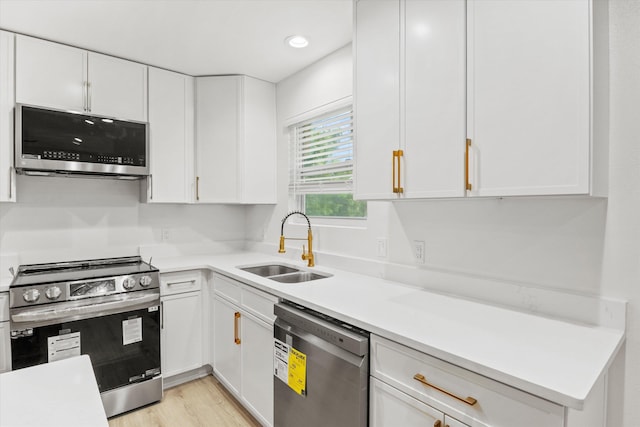 2224 Keith St, Tallahassee, FL 32310 - kitchen with appliances with stainless steel finishes, white cabinets, light countertops, and light wood finished floors