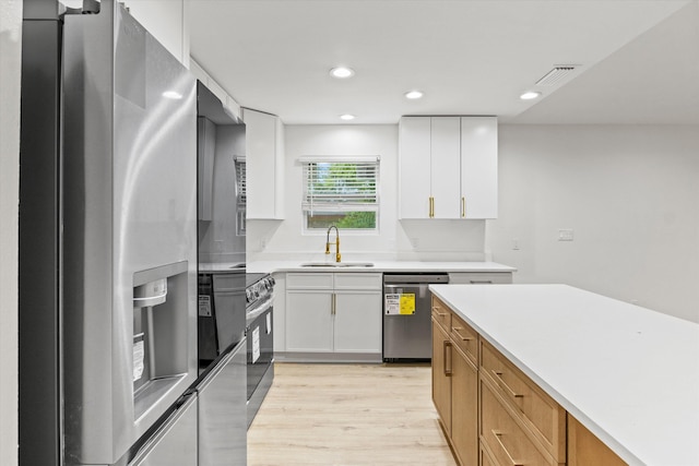 2224 Keith St, Tallahassee, FL 32310 - kitchen featuring stainless steel appliances, light wood-type flooring, light countertops, recessed lighting, and white cabinets