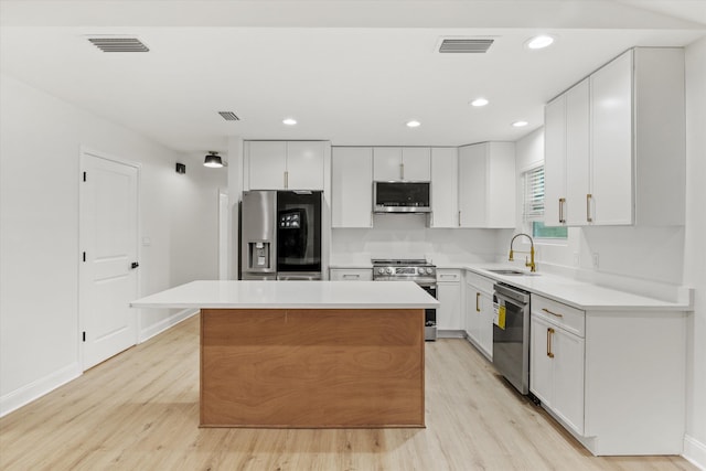 2224 Keith St, Tallahassee, FL 32310 - kitchen featuring appliances with stainless steel finishes, light wood-type flooring, a center island, white cabinetry, and recessed lighting