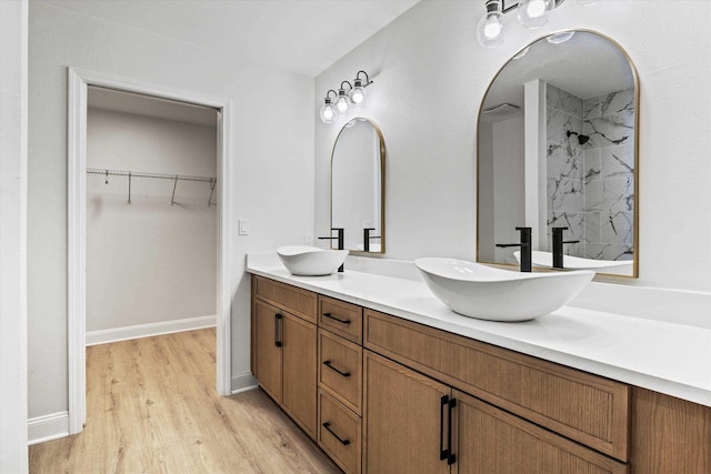 2224 Keith St, Tallahassee, FL 32310 - bathroom featuring double vanity, a marble finish shower, wood finished floors, and a spacious closet