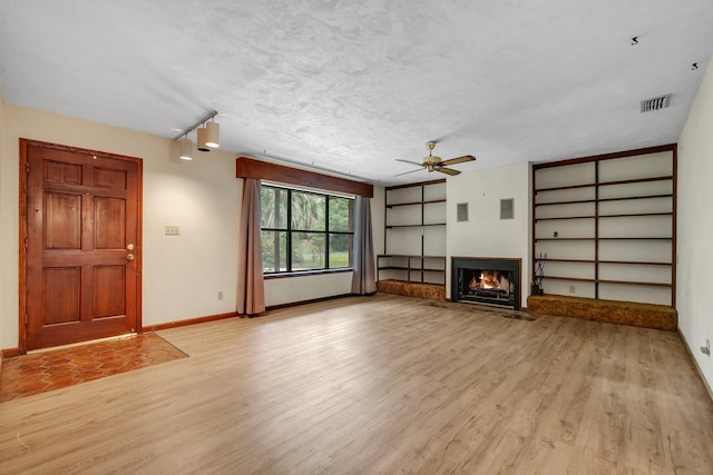 2104 Alton Rd, Tallahassee, FL 32303 - unfurnished living room with light wood finished floors, ceiling fan, a lit fireplace, and baseboards