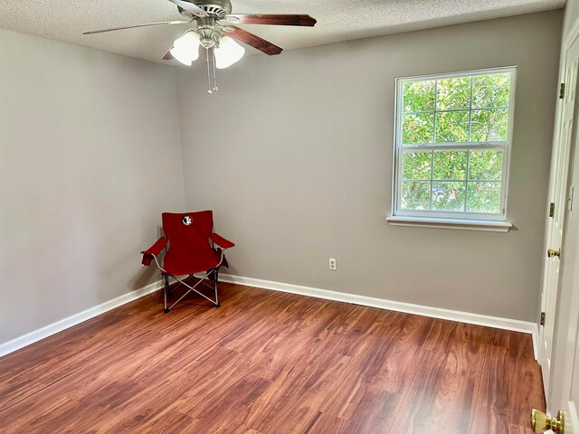 empty room featuring a textured ceiling, hardwood / wood-style flooring, and ceiling fan