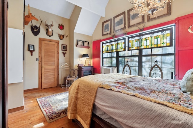 bedroom with a chandelier, light wood-type flooring, high vaulted ceiling, and cooling unit