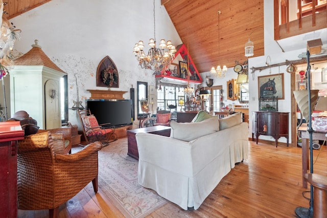 living room with wooden ceiling, an inviting chandelier, high vaulted ceiling, and light hardwood / wood-style floors