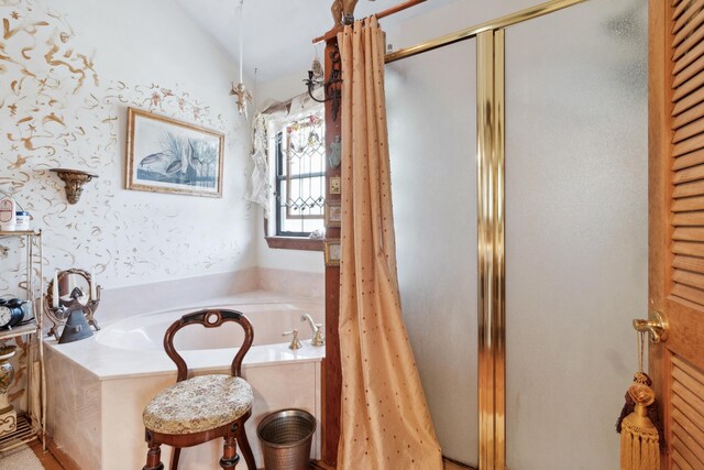 bathroom with shower with separate bathtub and vaulted ceiling