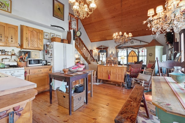 kitchen featuring white appliances, high vaulted ceiling, an inviting chandelier, decorative light fixtures, and light hardwood / wood-style floors