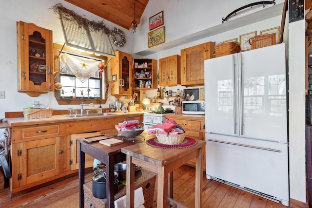 kitchen featuring white appliances, light hardwood / wood-style floors, wood ceiling, and sink