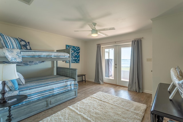 bedroom featuring crown molding, ceiling fan, access to exterior, light hardwood / wood-style floors, and french doors