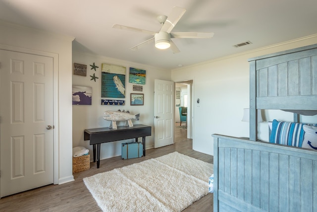 bedroom featuring crown molding, wood-type flooring, and ceiling fan