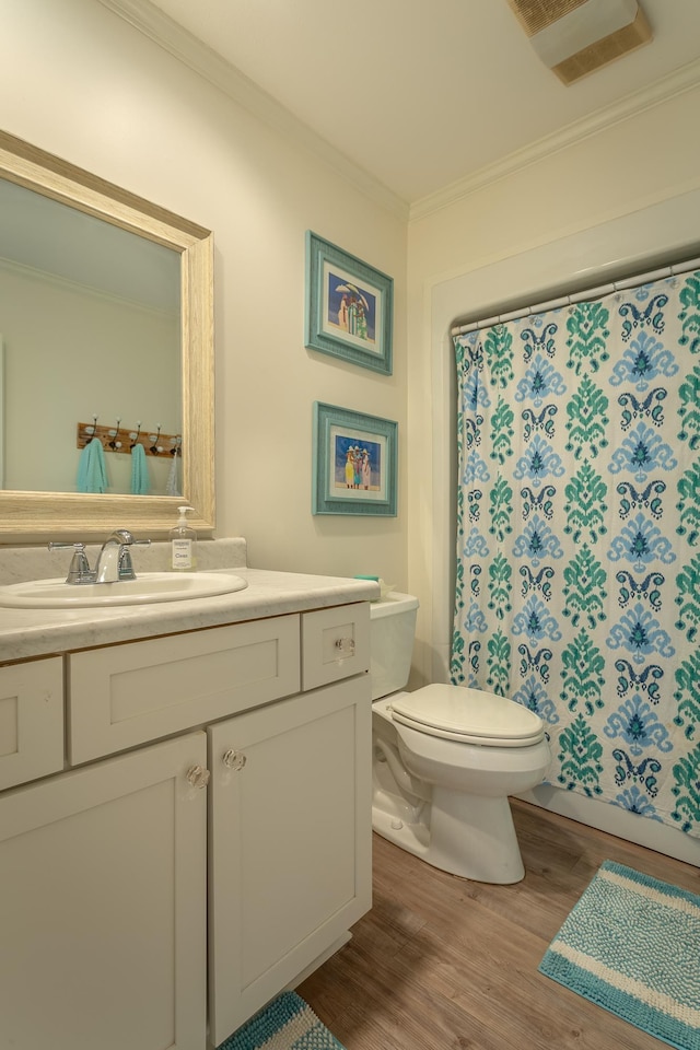 bathroom featuring crown molding, wood-type flooring, toilet, and vanity