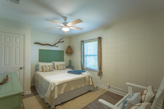 bedroom with crown molding, hardwood / wood-style flooring, and ceiling fan