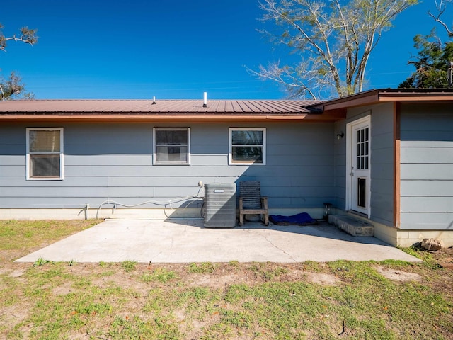 back of house with entry steps, a patio area, central AC, and metal roof