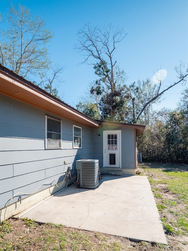 rear view of house featuring central air condition unit and a patio