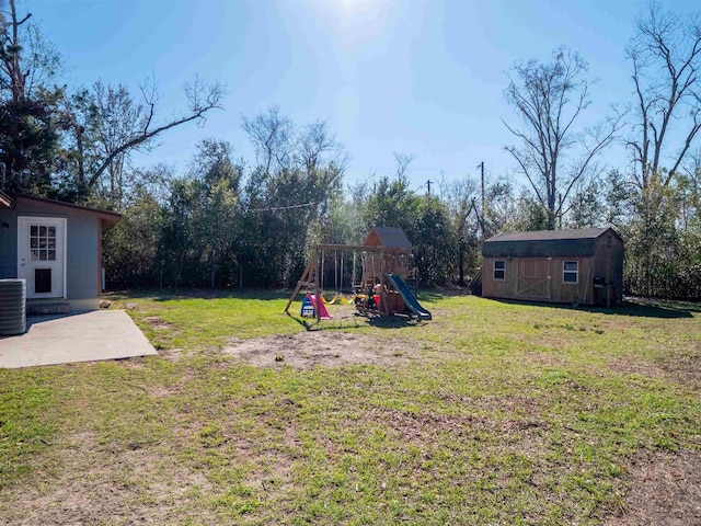 view of yard with an outbuilding, a playground, a patio, and a storage unit