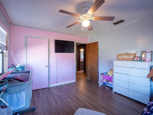 bedroom featuring dark wood-style floors, visible vents, a textured ceiling, and ornamental molding