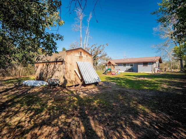 exterior space with a playground, an outdoor structure, and a shed