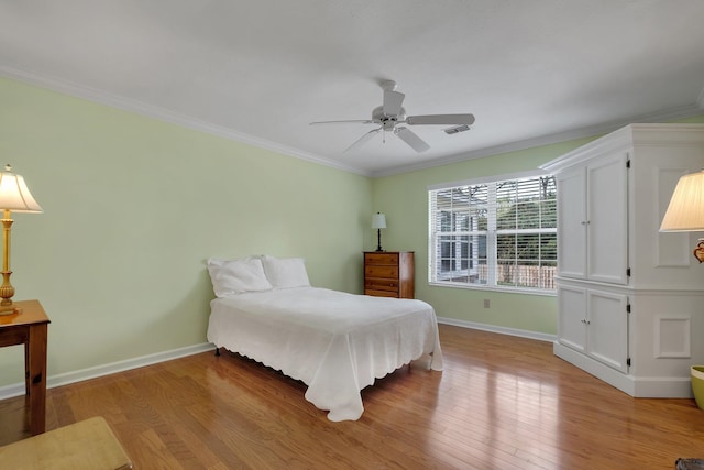 bedroom with light hardwood / wood-style floors, ceiling fan, and ornamental molding