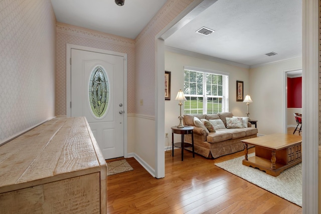 entryway featuring wood-type flooring and ornamental molding