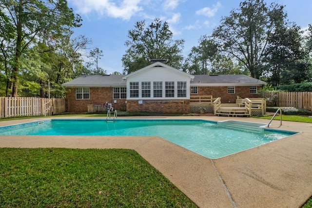 view of pool featuring a lawn and a deck