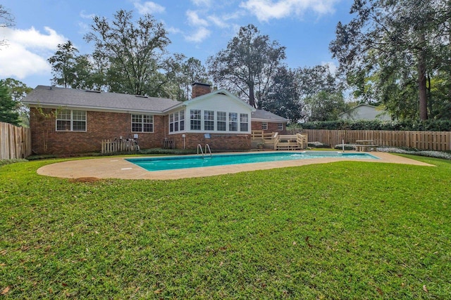 view of pool with a diving board, a yard, and a patio