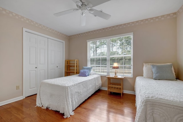 bedroom with a closet, hardwood / wood-style flooring, and ceiling fan