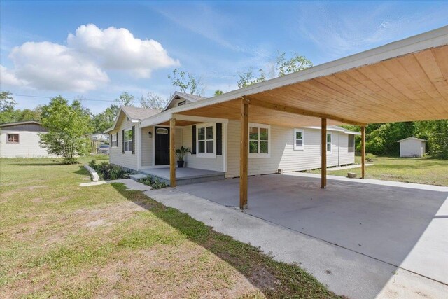1822 N US-221, Perry, FL 32347 - exterior space featuring a porch, a front yard, an outbuilding, a carport, and a storage unit