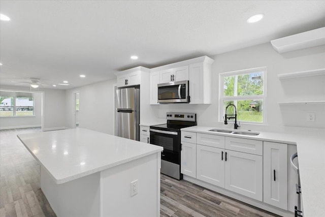 1822 N US-221, Perry, FL 32347 - kitchen with open shelves, appliances with stainless steel finishes, a sink, light wood-style floors, and a kitchen island