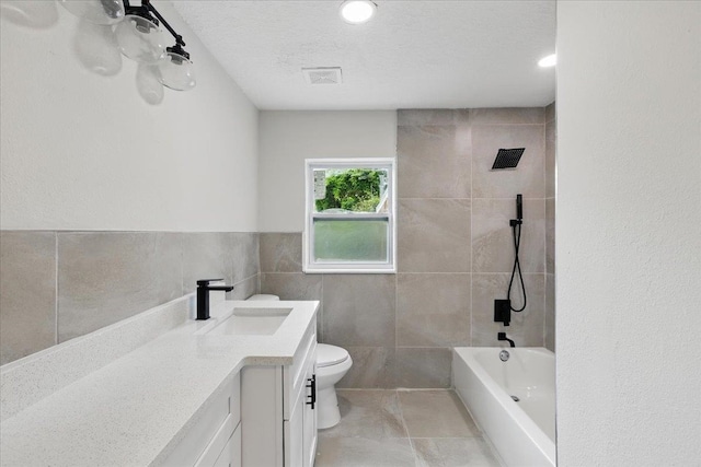 1822 N US-221, Perry, FL 32347 - bathroom featuring vanity, visible vents, toilet, tile walls, and shower / washtub combination