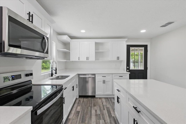 1822 N US-221, Perry, FL 32347 - kitchen featuring visible vents, open shelves, wood finished floors, a sink, and appliances with stainless steel finishes