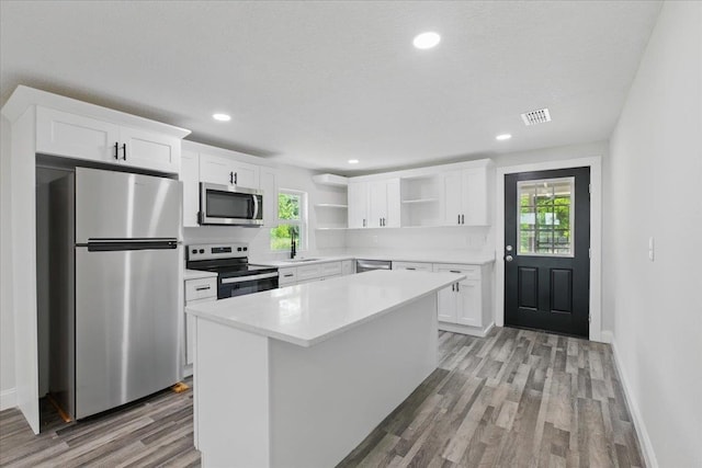 1822 N US-221, Perry, FL 32347 - kitchen with white cabinets, stainless steel appliances, open shelves, and light wood-style flooring