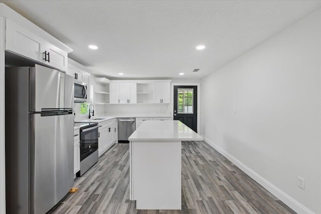 1822 N US-221, Perry, FL 32347 - kitchen featuring a sink, appliances with stainless steel finishes, open shelves, and wood finished floors