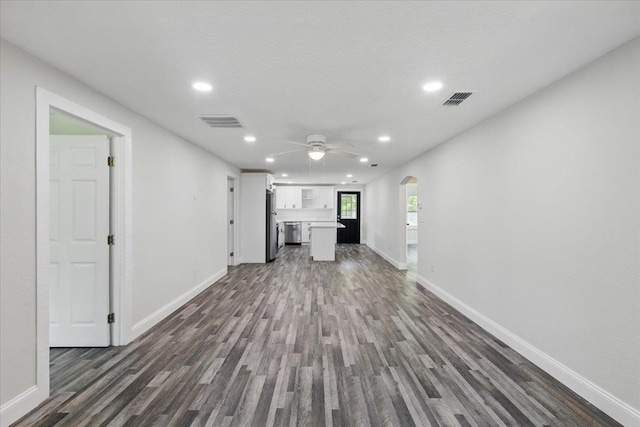 1822 N US-221, Perry, FL 32347 - unfurnished living room featuring dark wood-style flooring, visible vents, arched walkways, baseboards, and recessed lighting