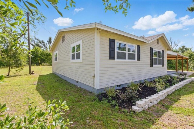 1822 N US-221, Perry, FL 32347 - view of side of home featuring a yard, crawl space, and a carport